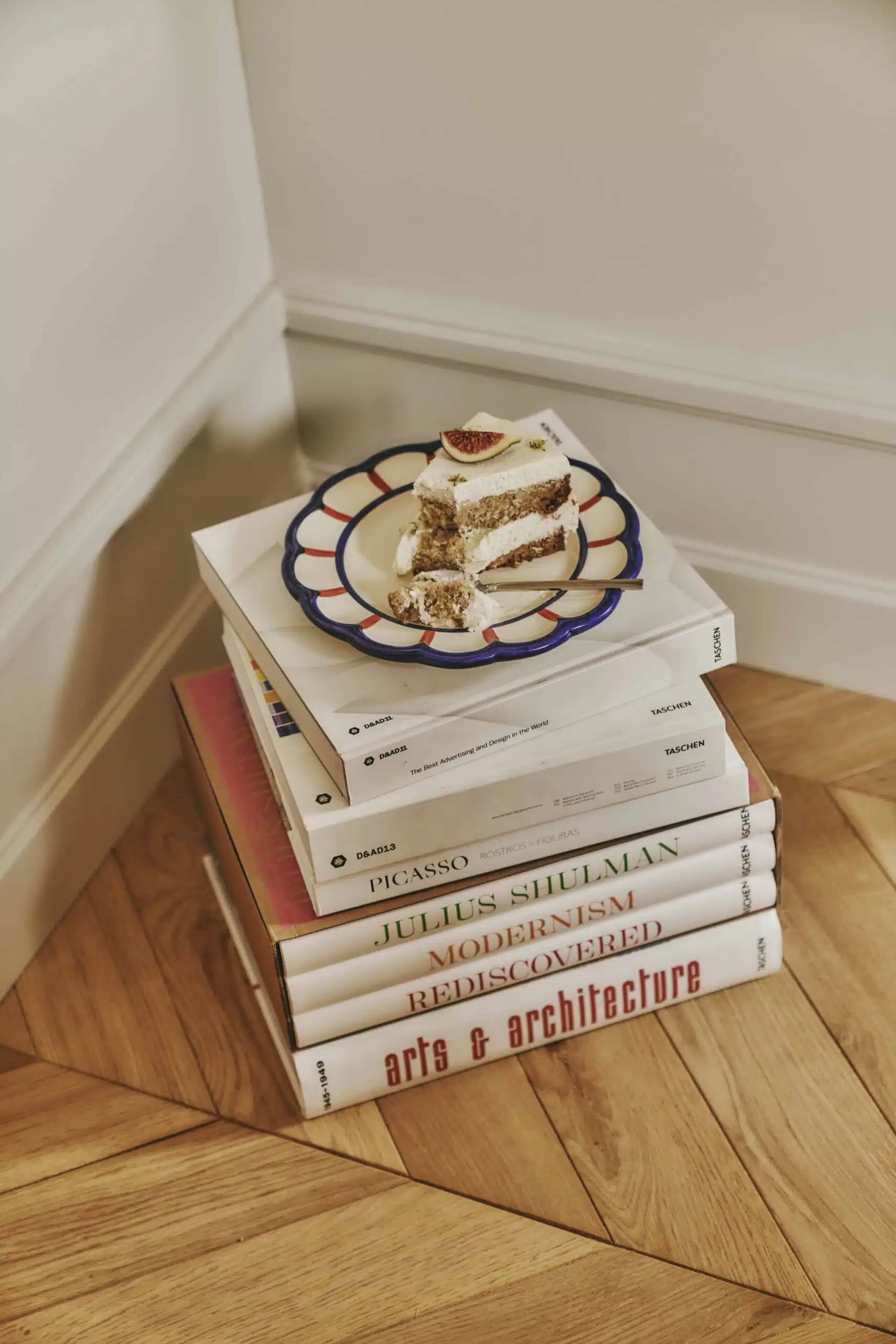 Plato pequeño con un pedazo de tarta sobre libros de arte